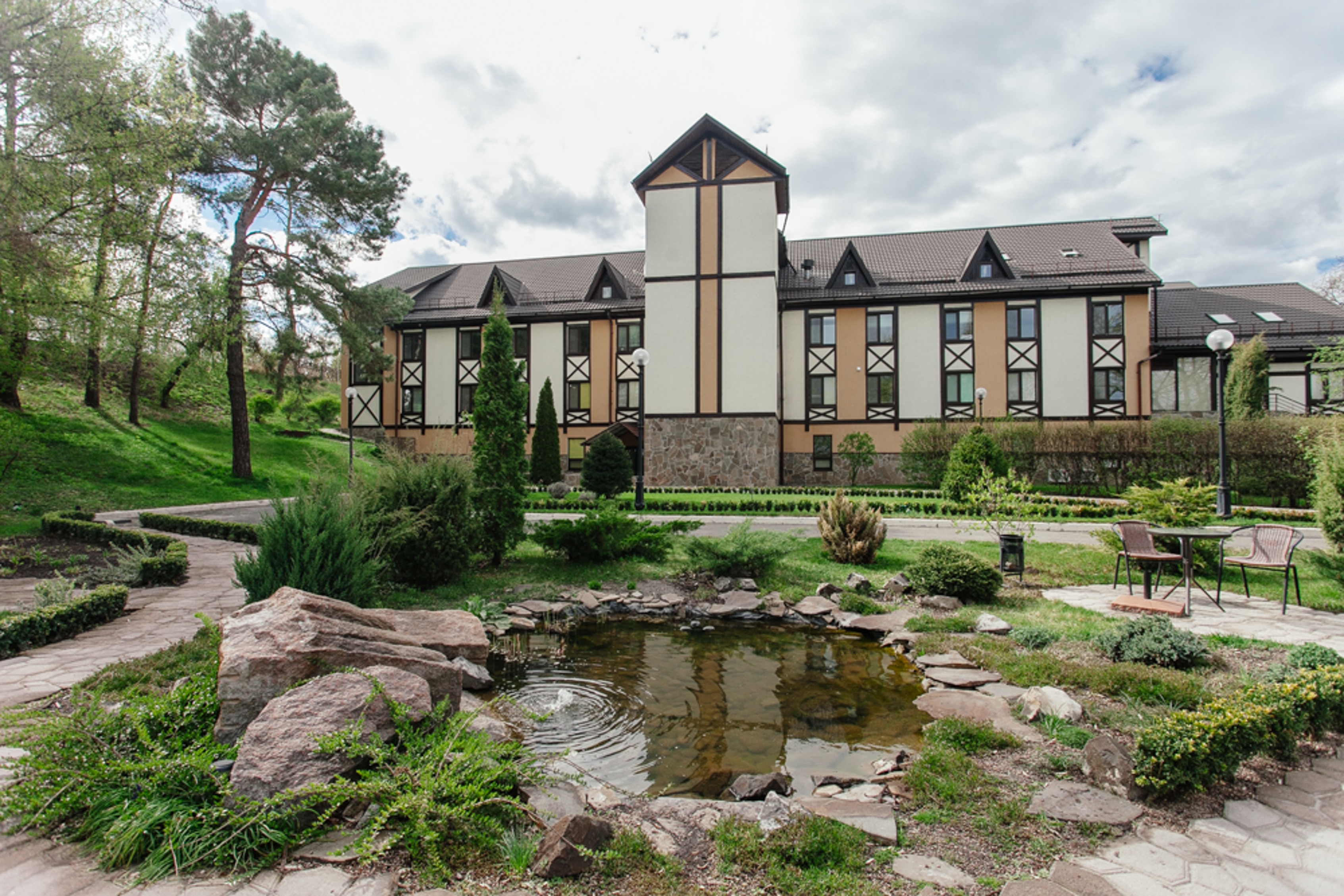 LISOD pastoral hospital campus with gardens, pond and chalet style architecture